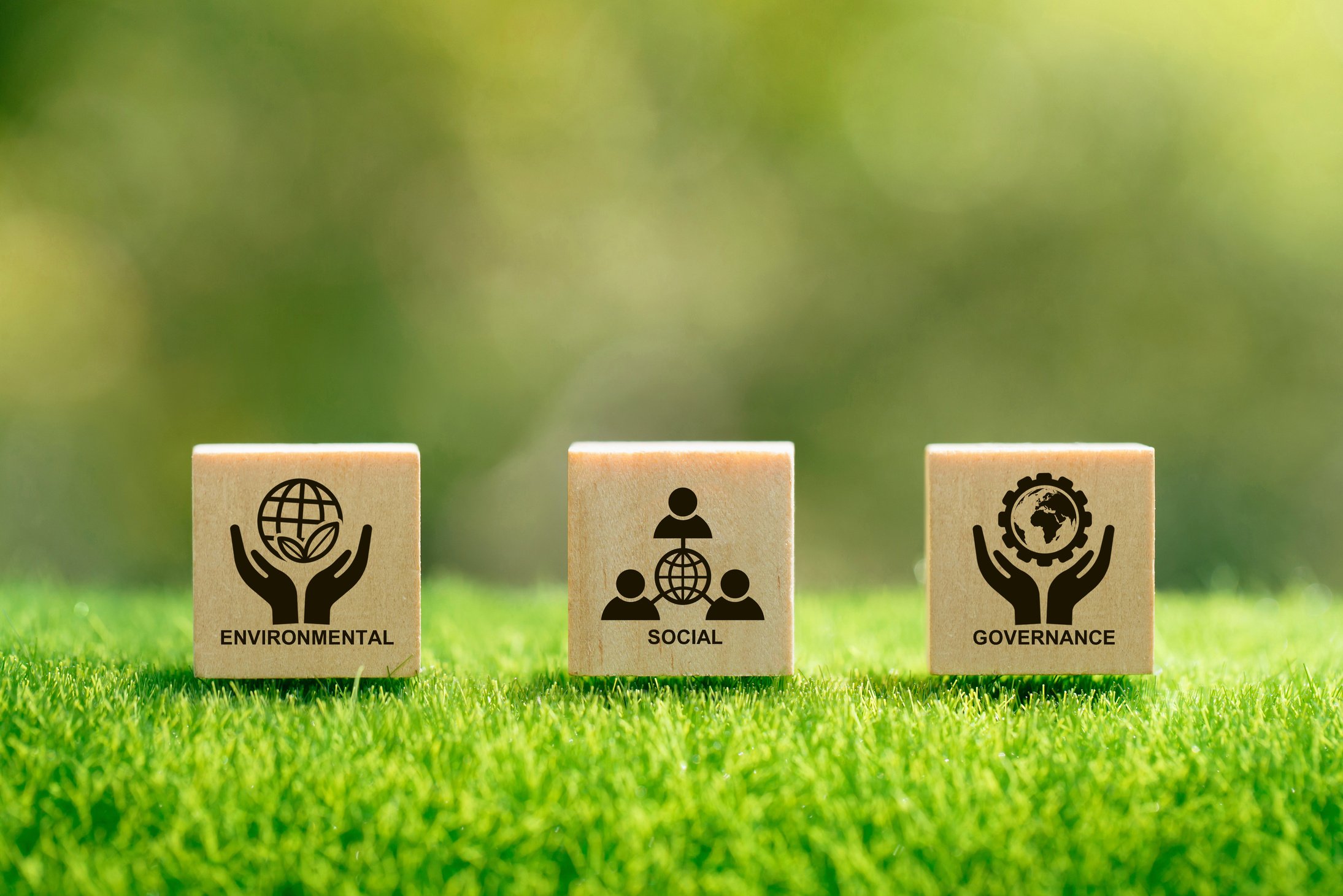 ESG concept of environmental, social and governance. Sustainable and ethical business.wooden cube with text "ESG" surrounding with ESG icon on beautiful green background.World environment day